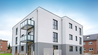 Außenansicht eines Mehrfamilienhaus mit Netto-Null-Standard in moderner Holzbauweise.