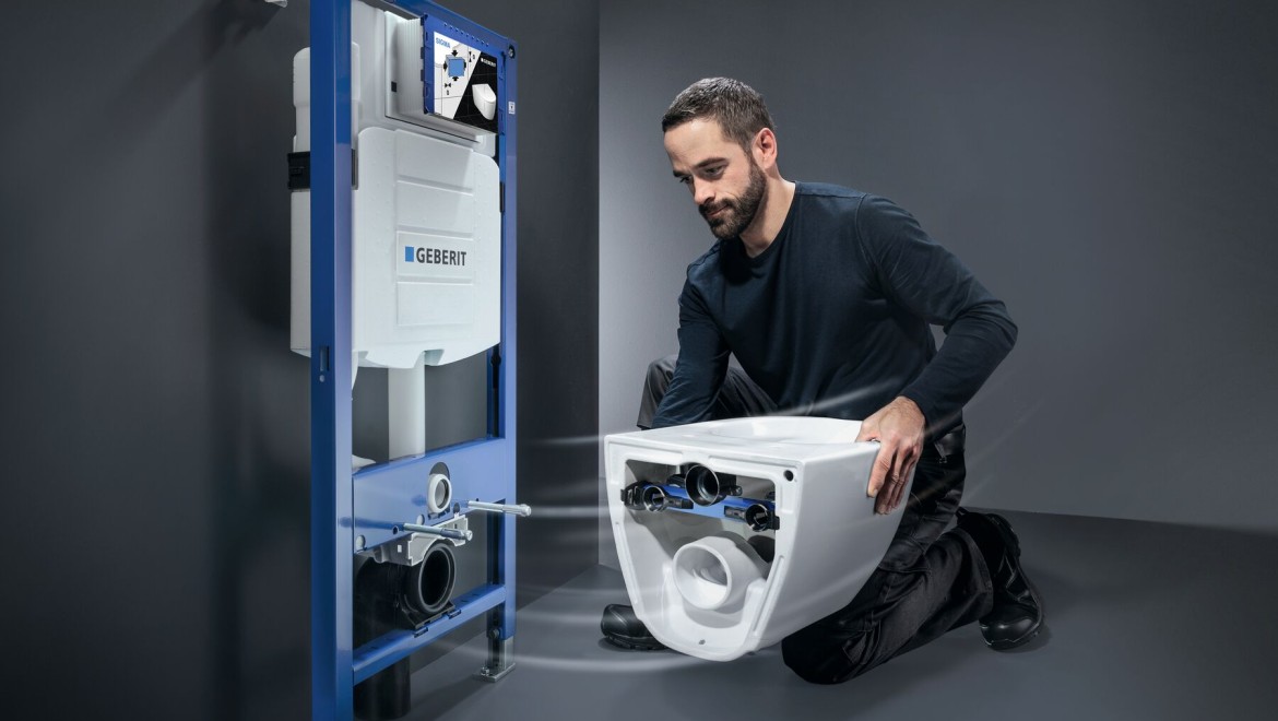 Installateur montiert WC-System bestehen aus Geberit Sigma UP-Spülkasten und Geberit Acanto WC