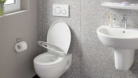 Wandhängendes WC an einer Wand mit Terrazzo-Fliesen. Wandhängendes WC an einer Wand mit Terrazzo-Fliesen.