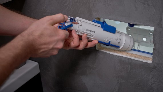 Ein Mann installiert ein Geberit Spülventil in einem Unterputzspülkasten (© Ben Huggler) Ein Mann installiert ein Geberit Spülventil in einem Unterputzspülkasten (© Ben Huggler)