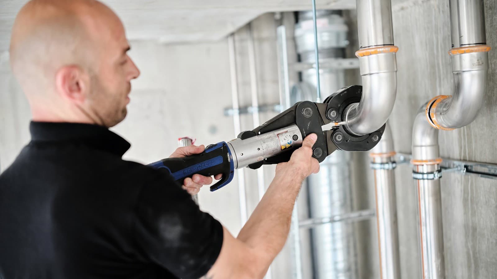 Installateur Danijel Pupic verarbeitet Mapress Therm mit Geberit Presswerkzeug. Installateur Danijel Pupic verarbeitet Mapress Therm mit Geberit Presswerkzeug.