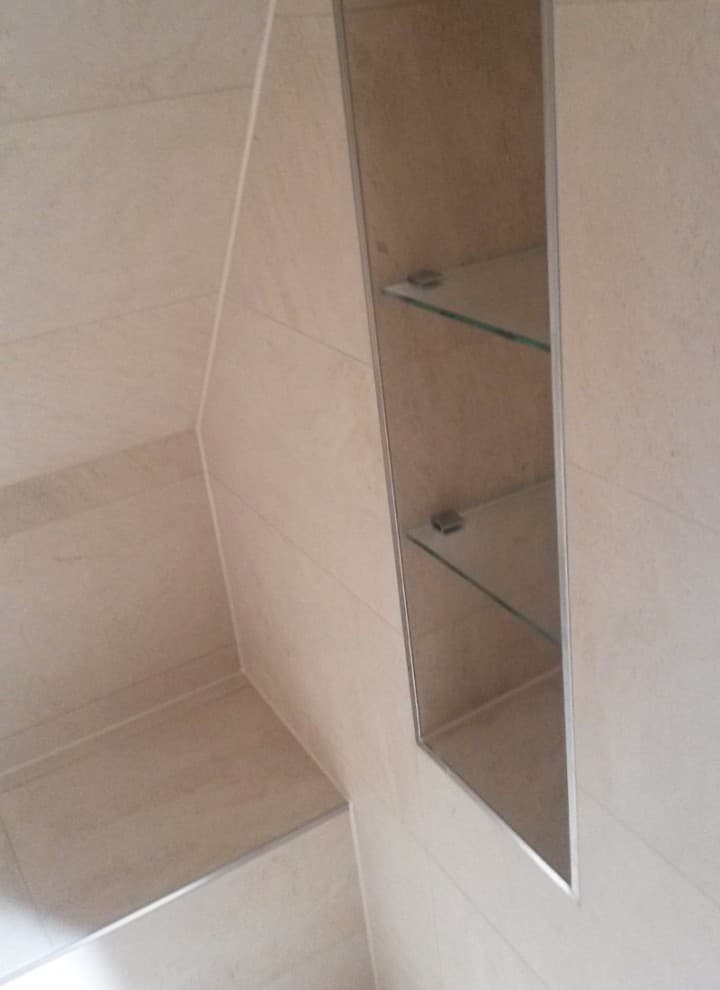 Dusche mit Sitzbank und Nischenablage unter einer Dachschräge Dusche mit Sitzbank und Nischenablage unter einer Dachschräge