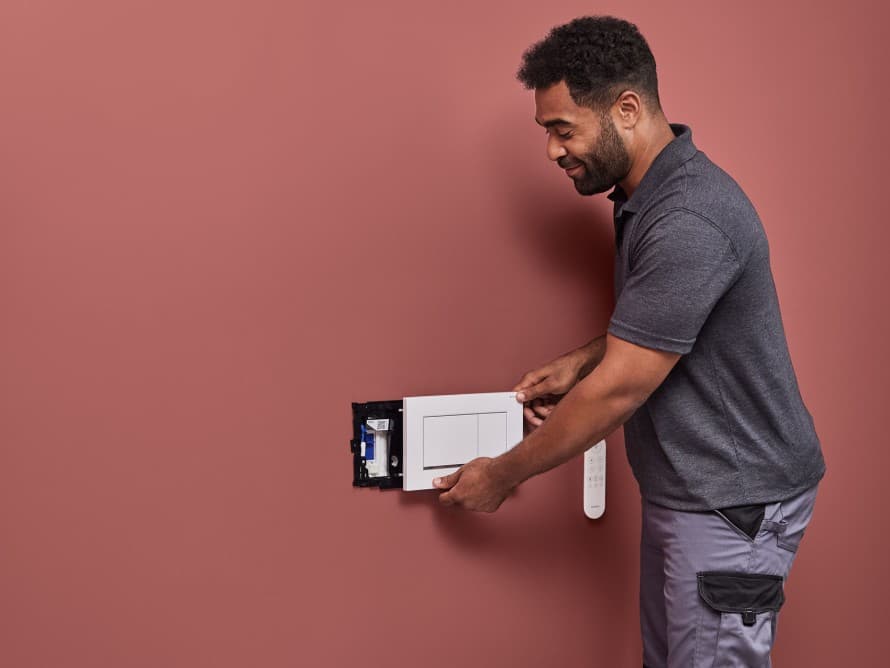 Mann installiert Geberit DuoFresh Geruchsabsaugung Mann installiert Geberit DuoFresh Geruchsabsaugung